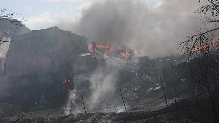 Black smoke covers Thessaloniki, Greece, after a forest fire spread to factories